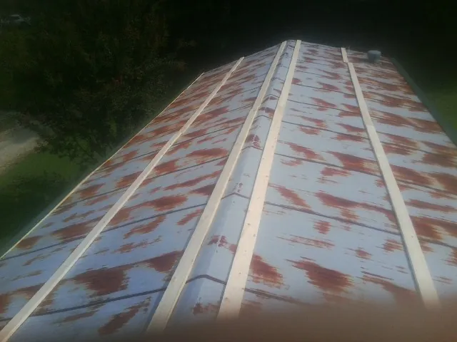 Rusted metal roof panels with new wood purlins before replacement — Storm Damage Roof Repair in Bainbridge by Roofing Brothers